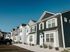 Row of stylish suburban townhouses with modern design and landscaped front yards.