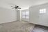 Bright living area with ceiling fan, carpeted floor, and large window offering natural light.