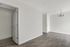 Bright and spacious room with elegant hardwood flooring and a stylish chandelier.
