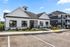 Charming modern apartment complex with classic architecture, featuring spacious windows and a well-maintained landscape.