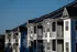 Modern apartment complex with elegant balconies and stylish architecture bathed in golden sunlight.