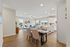 Inviting open-concept living area with elegant dining space and modern kitchen, featuring large windows for natural light.