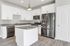 Contemporary kitchen with sleek stainless steel appliances, granite countertops, and elegant white cabinetry.
