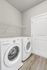 Contemporary laundry room featuring modern Whirlpool washer and dryer set against sleek gray walls and elegant wooden flooring.