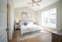 Bright and inviting bedroom with elegant decor, featuring a cozy bed, stylish nightstands, and large windows offering abundant natural light.