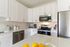 Modern kitchen with sleek stainless steel appliances, elegant white cabinetry, and a spacious countertop perfect for culinary creativity.