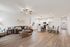 Inviting open-concept living room featuring modern decor, elegant dining space, and a sleek kitchen with white cabinetry and stainless steel appliances.