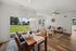 Inviting open-concept living and dining area with elegant furniture, abundant natural light, and scenic outdoor view.