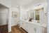 Elegant bathroom with modern double vanity, sleek countertops, and bright lighting in a chic apartment.