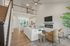 Modern open-concept living area featuring a cozy fireplace, elegant seating, and a stylish kitchen with an inviting breakfast bar.