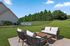 Inviting backyard patio featuring modern outdoor seating with scenic views of lush greenery and blue skies.