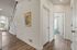 Inviting entryway showcasing elegant wood flooring, bright walls, and a welcoming atmosphere with stylish artwork.