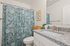 Bright and elegant bathroom featuring a modern granite countertop, chic floral shower curtain, and stylish decor accents.