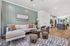 Elegant open-concept living space featuring a chic lounge area with a stylish sofa, modern kitchen, and ample natural light.