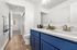 Modern bathroom with vibrant blue cabinetry, elegant double sinks, and sleek wood flooring, exuding a fresh and inviting ambiance.
