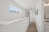 Bright and airy hallway with sleek finishes, featuring modern lighting and a scenic window view.