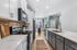 Modern kitchen with sleek white cabinets, stainless steel appliances, and a spacious marble countertop island leading to a sunlit dining nook.