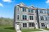 Modern townhouse with elegant three-story facade, large windows, and charming scenic surroundings, perfect for luxurious living.