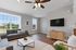 Bright and modern living room with large windows, comfortable sofas, and sleek hardwood flooring, perfect for relaxation and entertainment.