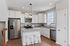 Modern kitchen with granite countertops, sleek stainless steel appliances, and elegant white cabinetry.