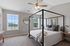 Bright and cozy bedroom with panoramic view, featuring an elegant four-poster bed, soft lighting, and natural light from large windows.