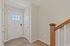Inviting entryway featuring a modern door with glass panels, sleek hardwood flooring, and stylish wooden staircase.