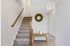 Bright entryway with a charming staircase, elegant wall decor, and stylish wooden bench, perfect for a welcoming home atmosphere.