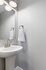 Elegant modern bathroom featuring a sleek pedestal sink with a minimalist chrome faucet and soft lighting.