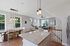 Bright open-concept living area with elegant dining space, modern kitchen island, and cozy seating corner, enhanced by large windows and stylish lighting.
