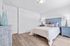 Elegant bedroom featuring a plush blue headboard, cozy bedding, and charming bedside lamps on matching tables.