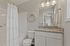 Elegant bathroom featuring a granite countertop, stylish lighting fixtures, and a decorative floral wreath for a touch of charm.