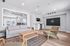 Modern office space featuring cozy seating with a sleek sofa, armchairs, and a stylish wooden coffee table, complemented by a large window for ample natural light.