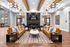 Elegant communal living space featuring modern leather sofas, stylish chandeliers, and a contemporary fireplace for a warm and inviting atmosphere.