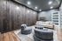 Chic living room with contemporary furnishings, featuring plush gray chairs, a cozy beige sofa, and elegant wooden accent wall.