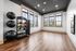 Bright and inviting home gym with large windows, modern exercise equipment, and sleek hardwood floors.