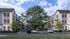 A serene courtyard at Fenland Townhomes featuring grand oak trees and benches for relaxation and gathering