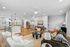 Contemporary open-plan living area with elegant furnishings, featuring a modern kitchen island and cozy seating, bathed in ample natural light.