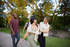 Vibrant group of friends enjoying a walk in a scenic park, surrounded by lush greenery and sunshine.