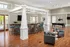 Resident game room with a stylish bar area with stone detailing and high-back stools, accompanied by a cozy seating area at Abberly Place Apartments in Garner, NC