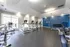 A large gym with treadmills, elliptical machines, and dumbbells at Abberly Place Apartments in Garner, NC