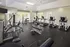 Gym with a variety of exercise equipment, rubber flooring, and large windows providing natural light and views of the greenery outside at Abberly Place Apartments in Garner, NC
