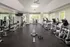 Bright and spacious fitness center featuring a variety of exercise equipment, including treadmills, ellipticals, strength training machines, and free weights at Abberly Place Apartments in Garner, NC