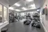 Bright and spacious gym with a variety of equipment including treadmills, elliptical machines, and weight machines at Abberly Place Apartments in Garner, NC