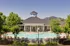 Pool and sundeck surrounded by lush landscaping at Abberly Place Apartments in Garner, NC