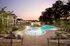 Swimming pool surrounded by a stone patio and lounge chairs at Abberly Place Apartments in Garner, NC