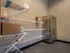 A package acceptance room featuring a wire shelf with neatly organized boxes and a refrigerator for storing perishable deliveries at Abberly Liberty Crossing Apartments in Charlotte, NC