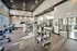 A gym featuring cardio equipment and weights, located in a building with large windows that allow natural light to flood the space at Abberly Liberty Crossing Apartments in Charlotte, NC