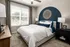 A bedroom featuring a bed and a prominent blue accent wall at Abberly Liberty Crossing Apartments in Charlotte, NC