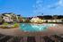 Swimming pool with patio and lounge chairs at Abberly Chase Apartments in Ridgeland, SC