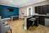 Clubhouse kitchen and entertaining area featuring sleek black cabinetry, a bar-style counter, a seating area with a table and chairs, and a flat-screen TV at Abberly Woods Apartments in Charlotte, NC